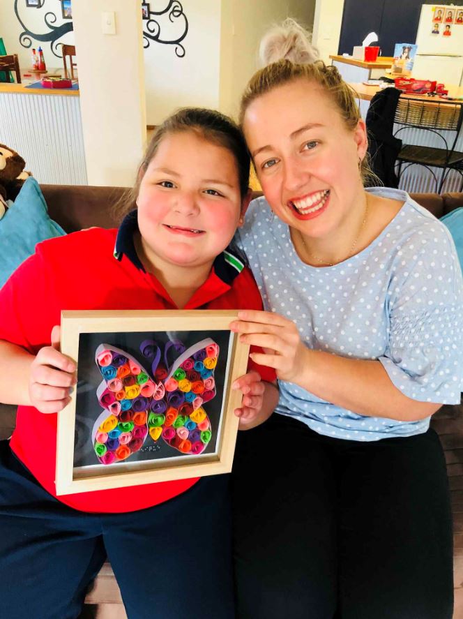 Paige receiving a handmade gift from Genique